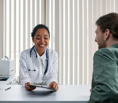 A doctor reviewing notes with a patient during a consultation