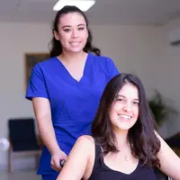 A nurse supporting a smiling, recovering patient in a bright clinic