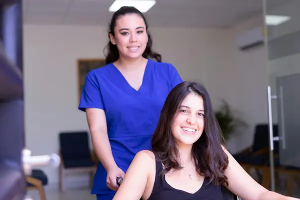 A nurse supporting a smiling, recovering patient in a bright clinic