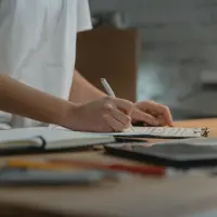 Someone working through a checklist on a clipboard at a desk