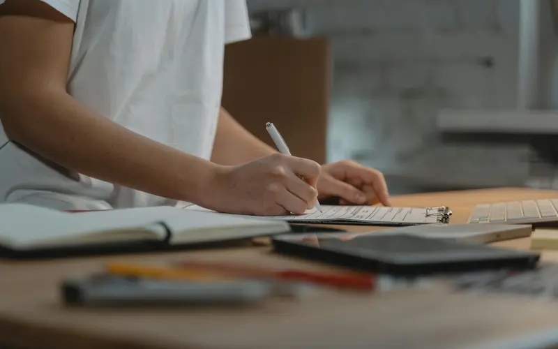 Someone working through a checklist on a clipboard at a desk